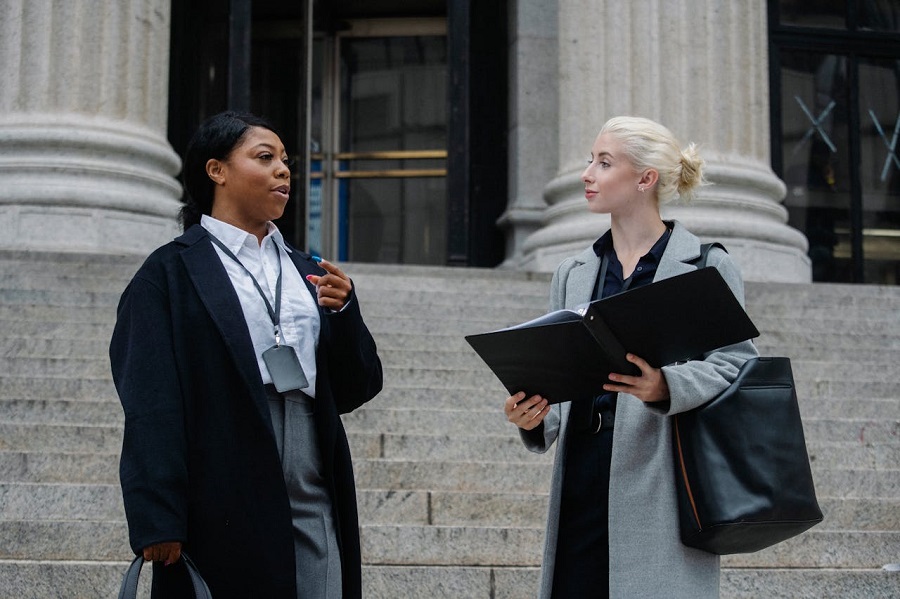 elegantes-partenaires-d-affaires-feminines-diverses-avec-des-documents-parlant-dans-la-rue