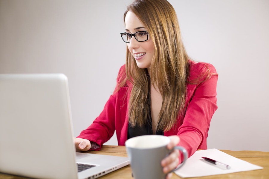 femme-utilisation-ordinateur-portable-quoique-tenue-tasse